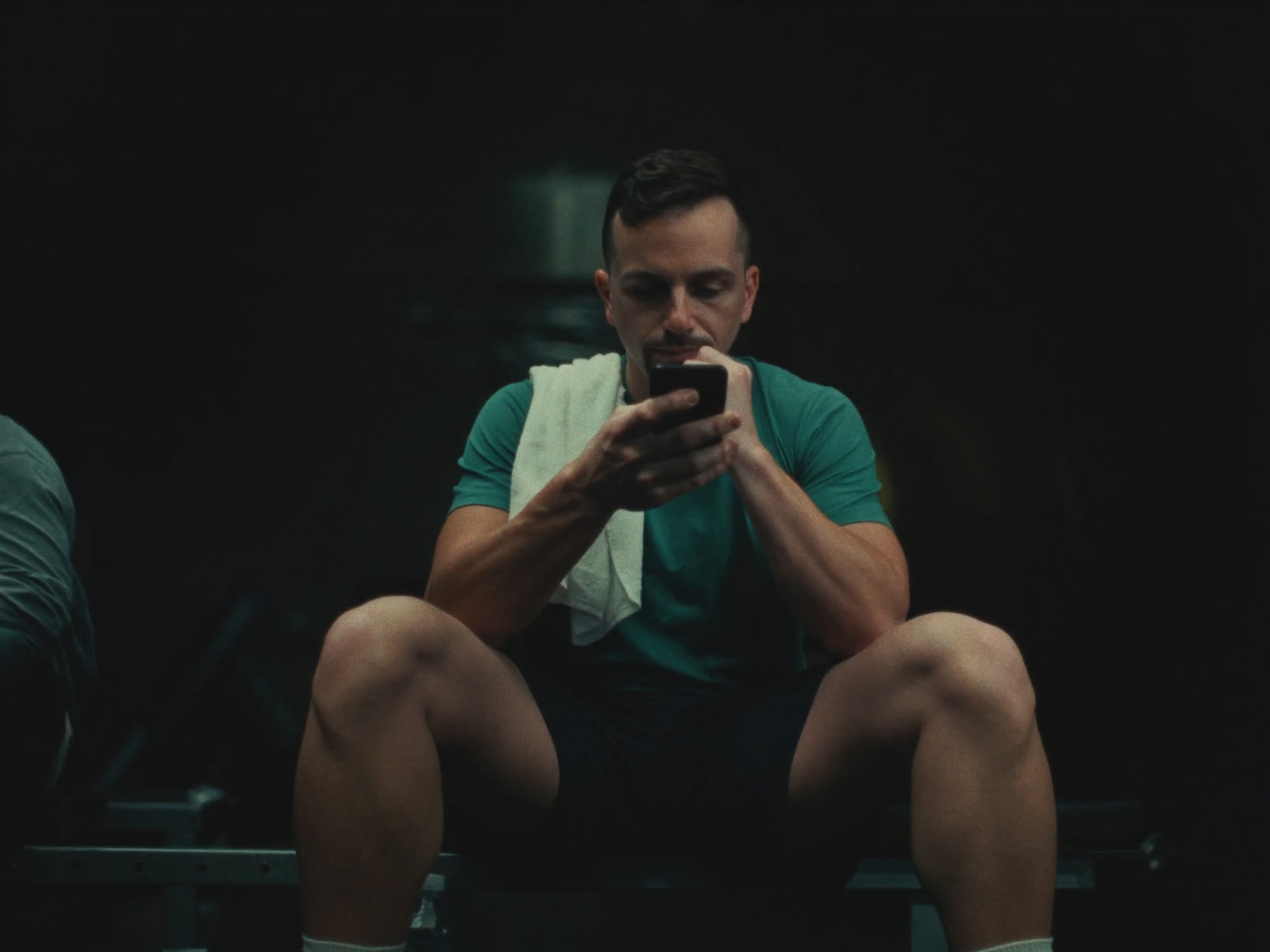 Man resting on a gym bench between sets